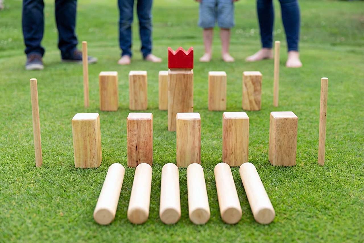 Familie spielt draußen Wikingerschach/Kubb